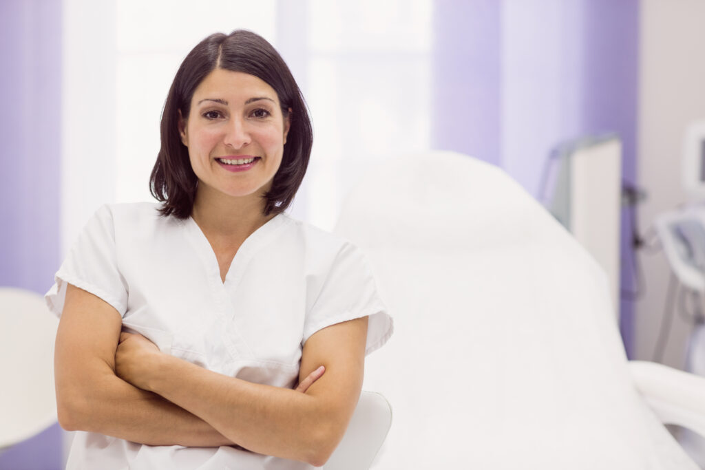 portrait of female dermatologist standing with arms crossed in clinic